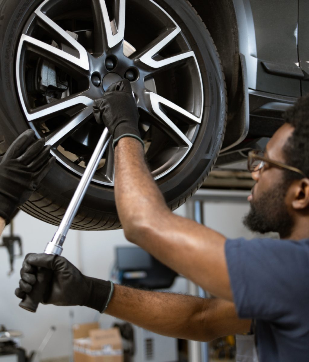 mechanics-working-on-car-wheel-in-auto-repair-shop-2024-12-14-05-11-41-utc-1500x1000 (1)